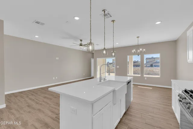 a view of a kitchen with a sink dishwasher a refrigerator with wooden floors
