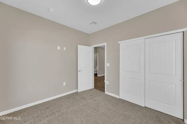 an empty room with windows and closet