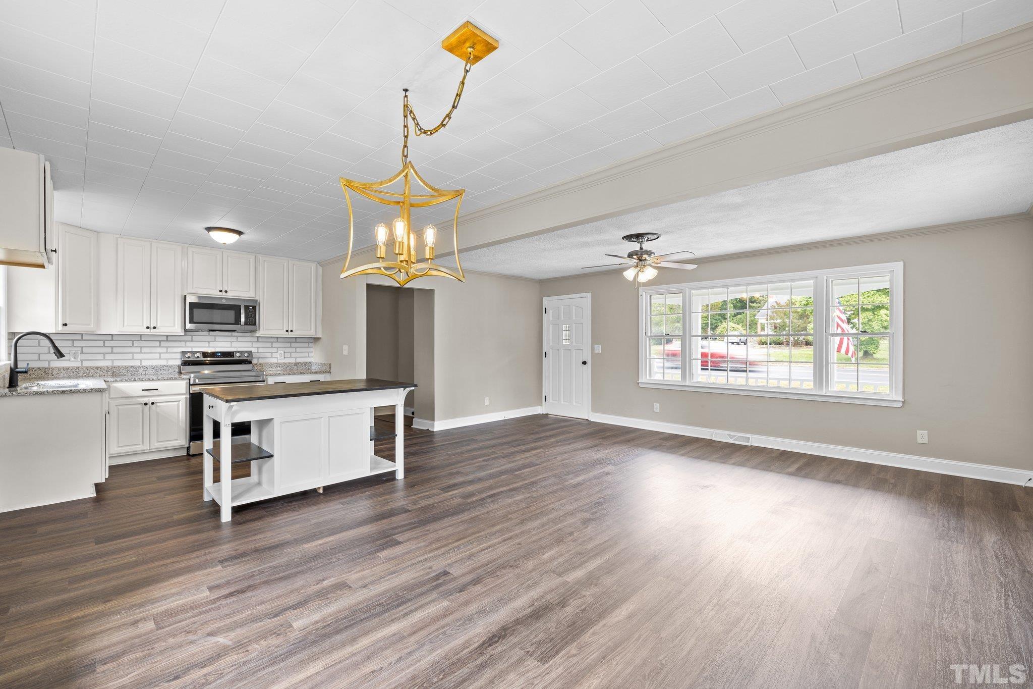 270 Burlington Road Roxboro, NC 27573 - Photo 7 of 37 a kitchen with kitchen island wooden floors appliances and cabinets