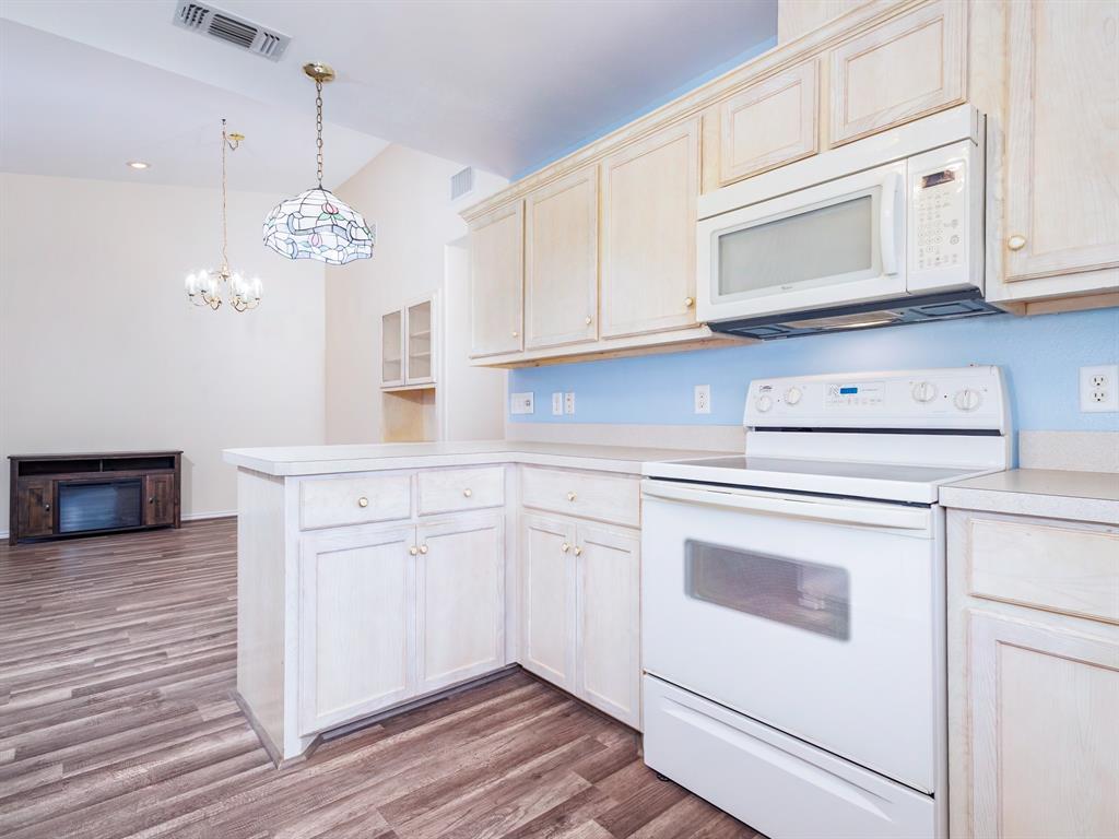 202 Abby Road Early, TX 76802 - Photo 11 of 28 a kitchen with stainless steel appliances granite countertop cabinets and wooden floor