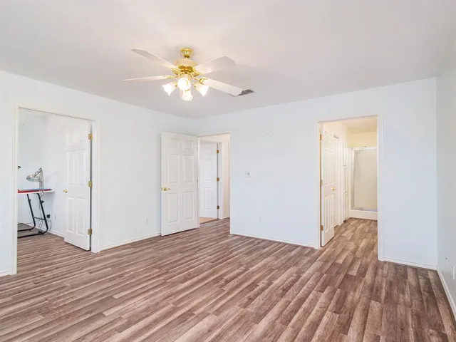 a view of empty room with wooden floor