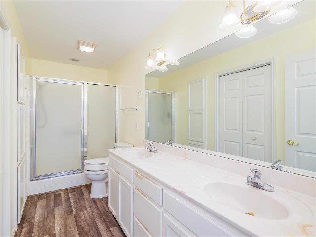202 Abby Road Early, TX 76802 - Photo 14 of 28 a bathroom with a double vanity sink a toilet and a shower