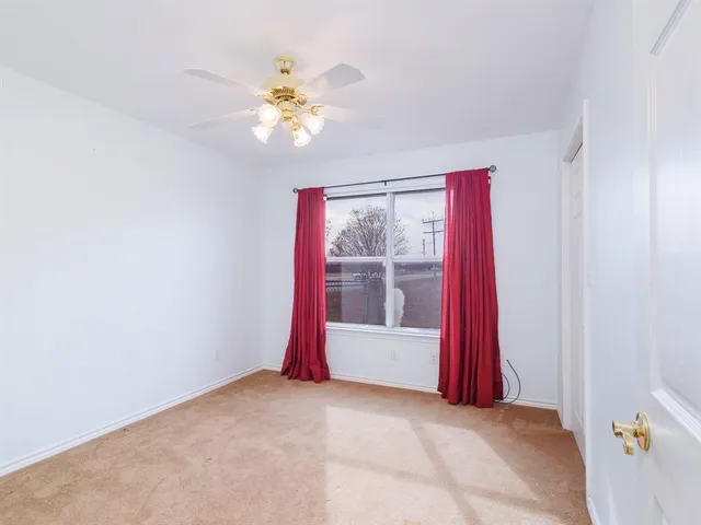 a view of a room with a chandelier fan and windows