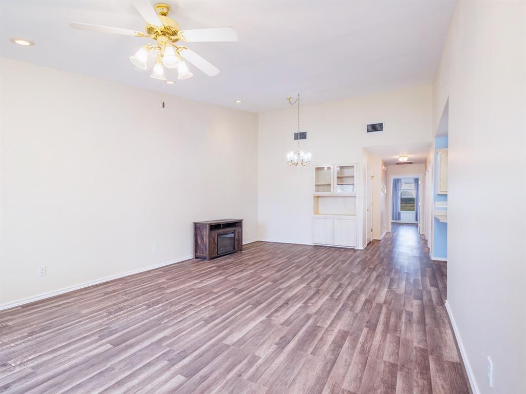 202 Abby Road Early, TX 76802 - Photo 6 of 28 a view of an empty room with wooden floor and a window