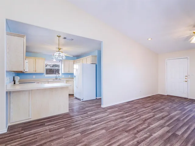 a view of kitchen with wooden floor and electronic appliances