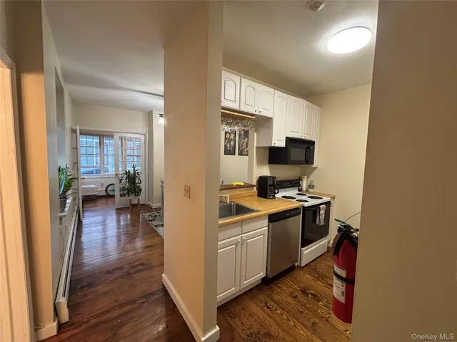 a view of a kitchen with a sink wooden floor and a living room