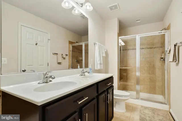 a bathroom with a sink double vanity granite toilet and shower