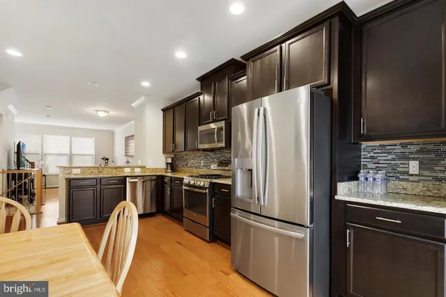 a kitchen with stainless steel appliances granite countertop a refrigerator stove microwave and sink