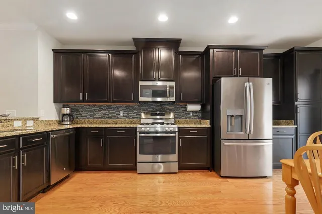 a kitchen with granite countertop stainless steel appliances and wooden cabinets
