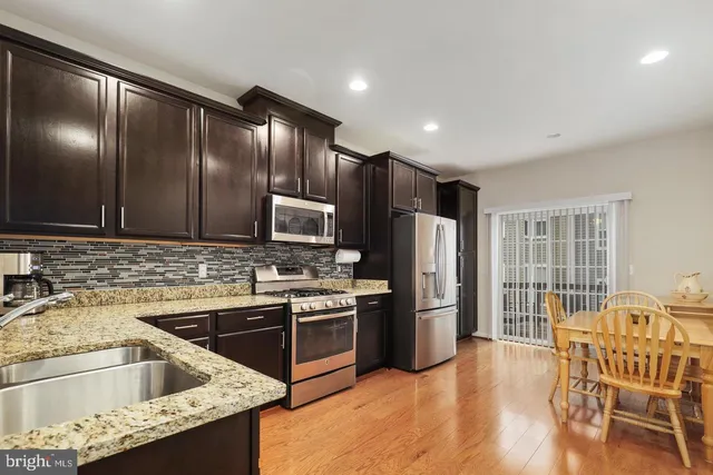 a kitchen that has a sink cabinets and stainless steel appliances