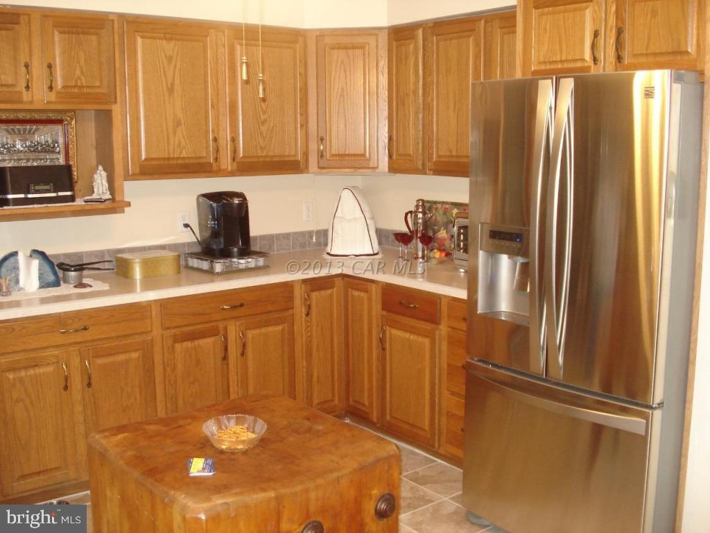 8037 Downs Road Newark, MD 21841 - Photo 11 of 23 a kitchen with stainless steel appliances granite countertop a refrigerator a sink and white cabinets