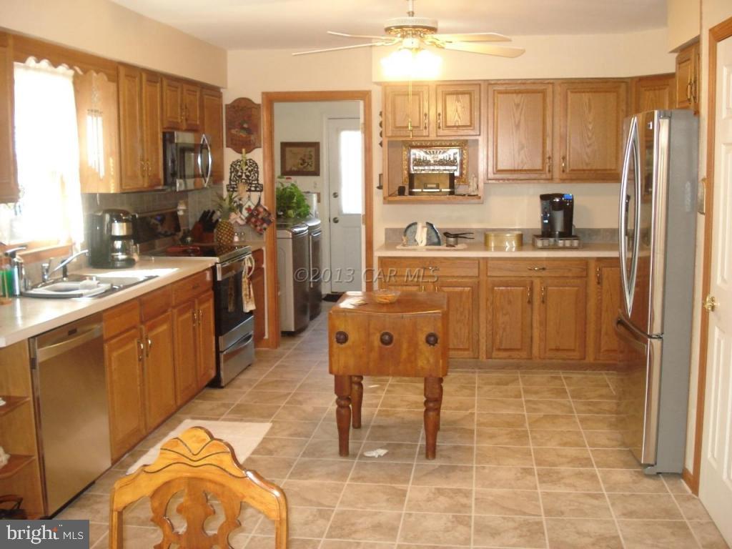 8037 Downs Road Newark, MD 21841 - Photo 12 of 23 a kitchen with stainless steel appliances granite countertop a stove top oven a sink a dining table and chairs