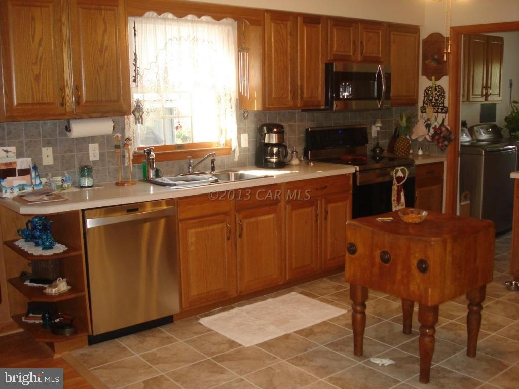 8037 Downs Road Newark, MD 21841 - Photo 13 of 23 a kitchen with stainless steel appliances granite countertop a sink a stove a refrigerator cabinets and a window