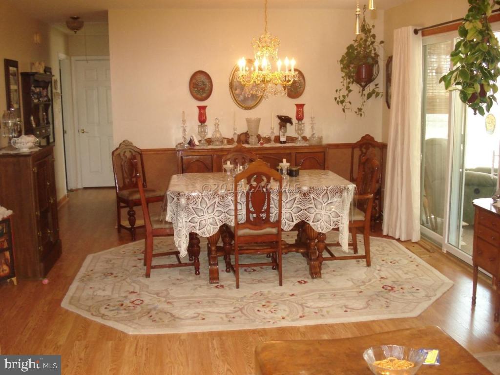 8037 Downs Road Newark, MD 21841 - Photo 14 of 23 a dining room with furniture a rug and wooden floor