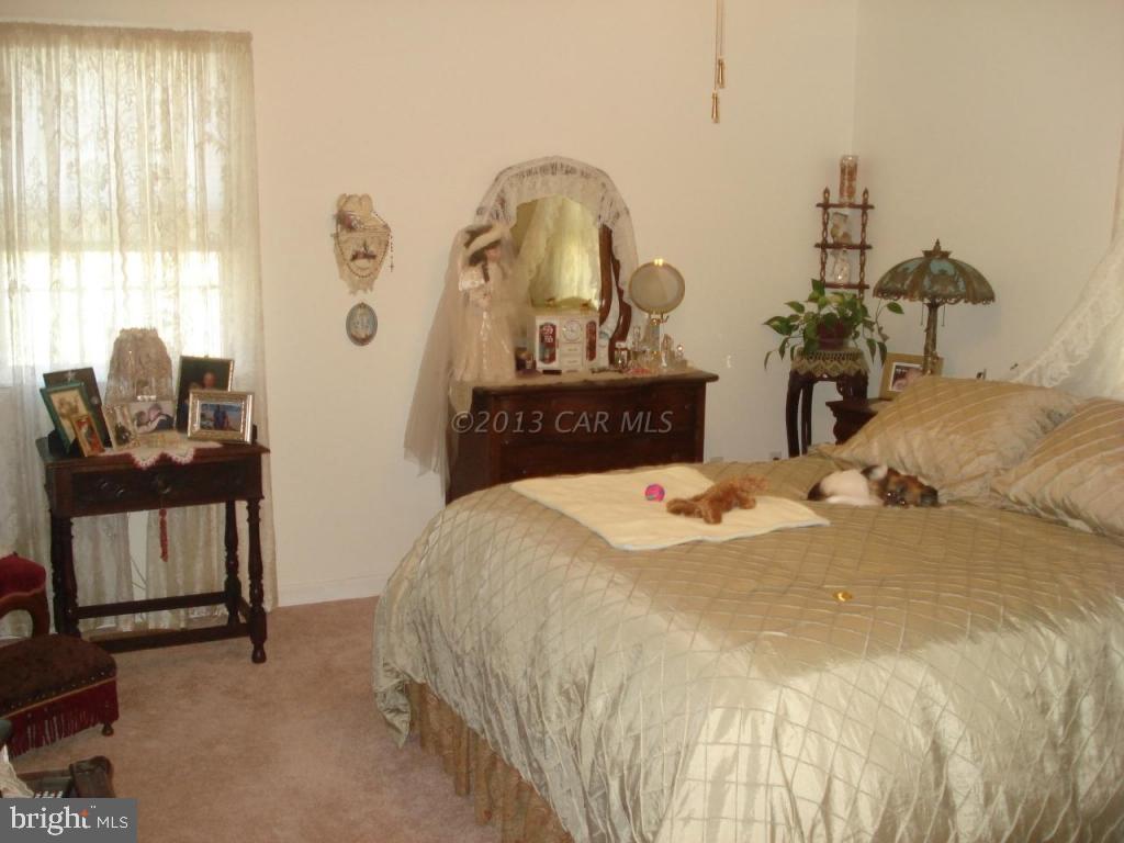8037 Downs Road Newark, MD 21841 - Photo 18 of 23 a bedroom with a bed and dresser with mirror