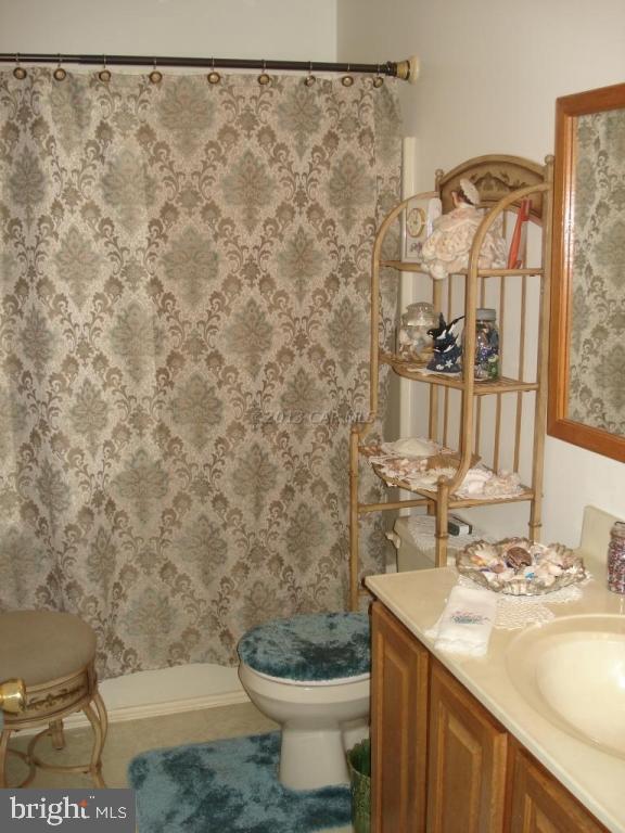 8037 Downs Road Newark, MD 21841 - Photo 23 of 23 a bathroom with a granite countertop sink and a toilet