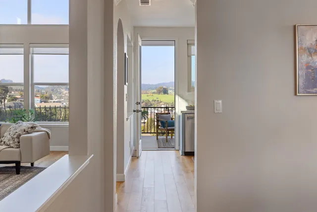 a view of a hallway to a livingroom with furniture