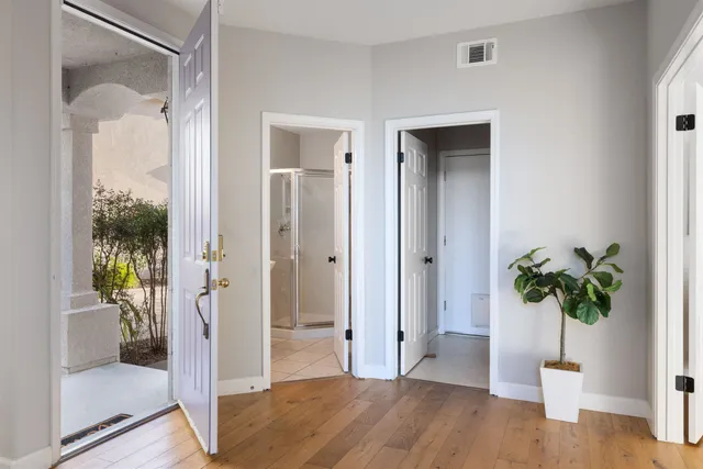 a view of a hallway with wooden floor and a glass door