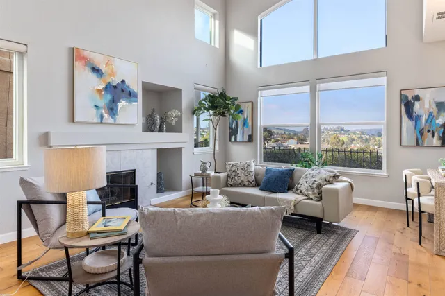 a living room with furniture large window and fireplace