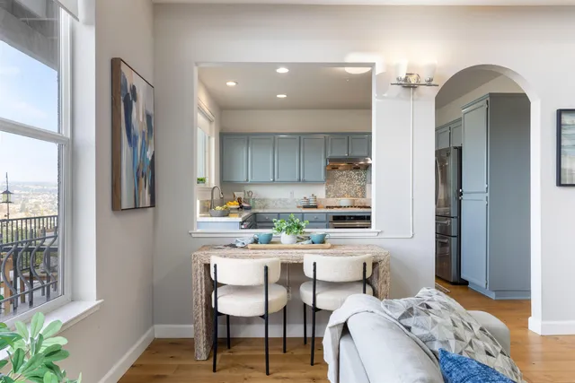 a kitchen with a dining table chairs and refrigerator