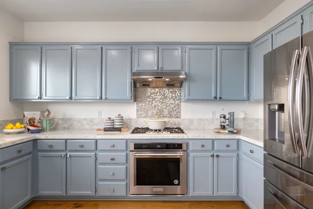 a kitchen with stainless steel appliances granite countertop a stove a refrigerator and a sink