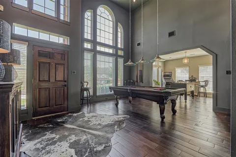 a kitchen with granite countertop a sink stainless steel appliances white cabinets and wooden floor