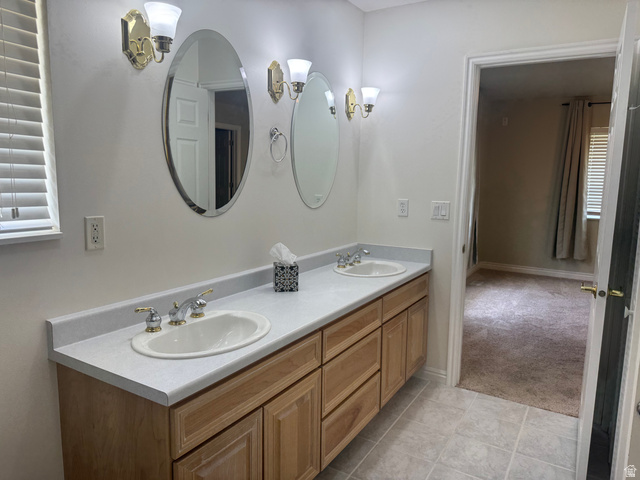 88 Canterbury Lane Logan, UT 84321 - Photo 18 of 37 Double vanity with light wood cabinetry, dual oval mirrors, and sconce lighting