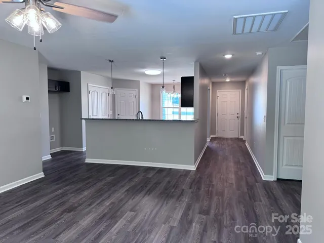 a view of a kitchen with wooden floor and a window