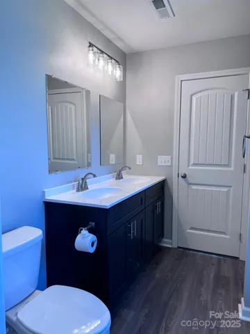 a bathroom with a toilet a sink and mirror
