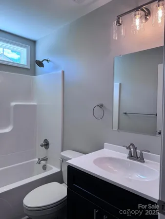 a bathroom with a granite countertop bathtub sink vanity mirror and toilet