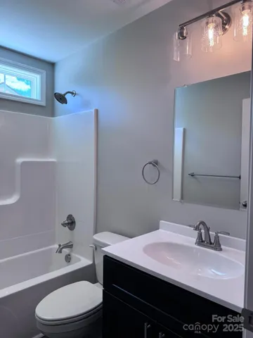 a bathroom with a granite countertop bathtub sink vanity mirror and toilet