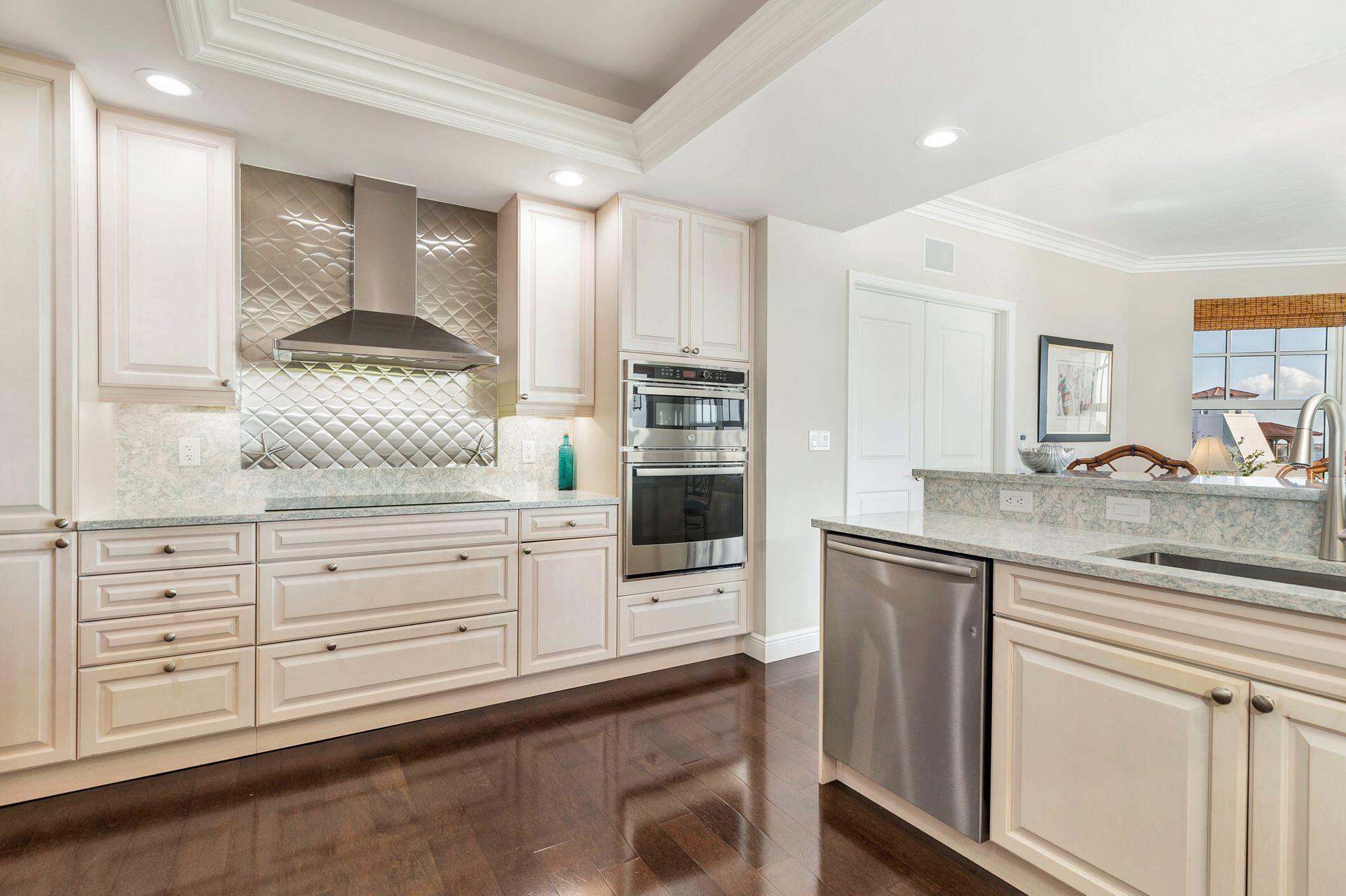 700 Highway 1, Unit 401 Jupiter, FL 33477 - Photo 18 of 39 a kitchen with stainless steel appliances kitchen island granite countertop a stove a sink and a refrigerator