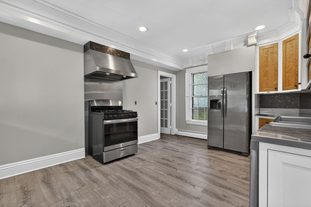 12 Crown Street Worcester, MA 01609 - Photo 12 of 42 a kitchen with stainless steel appliances a refrigerator and a stove top oven
