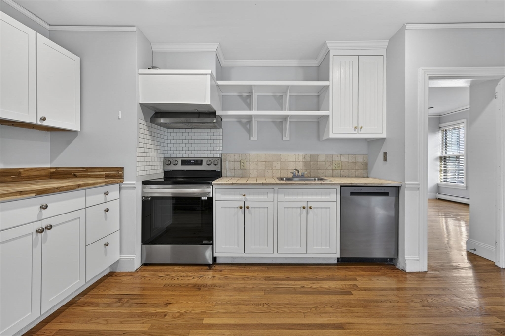 12 Crown Street Worcester, MA 01609 - Photo 28 of 42 a kitchen with granite countertop a stove and white cabinets