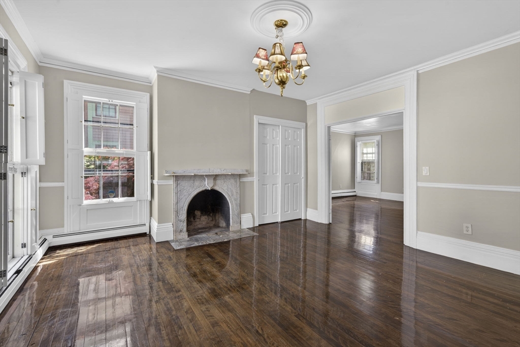 12 Crown Street Worcester, MA 01609 - Photo 3 of 42 a view of a livingroom with a fireplace a chandelier and wooden floor