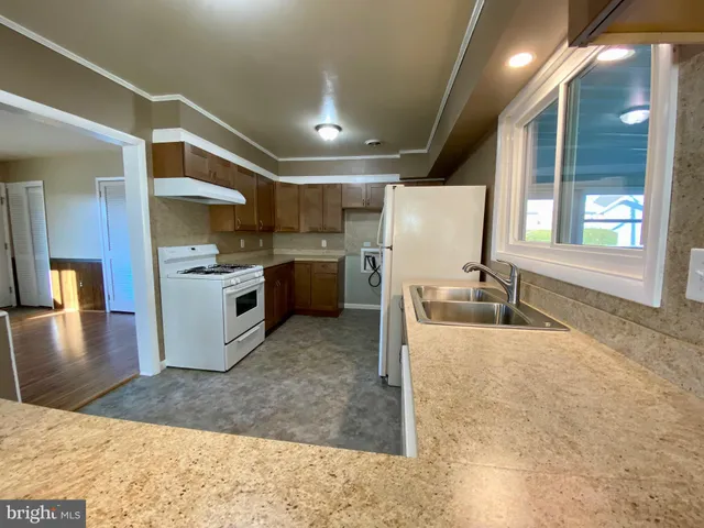 a view of a kitchen with stainless steel appliances granite countertop a sink stove and refrigerator