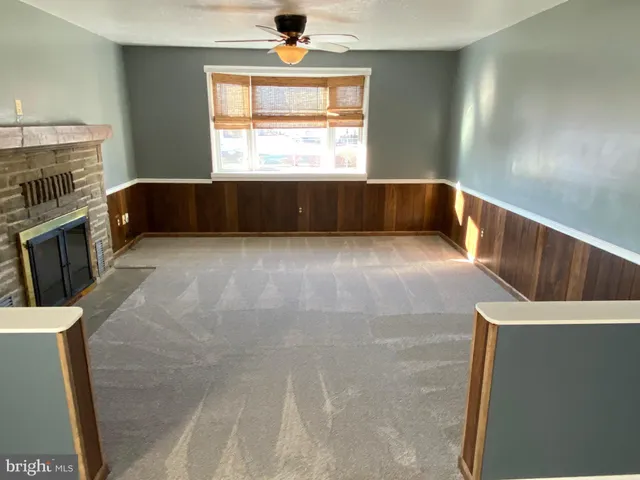 a view of an empty room with a fireplace and a window
