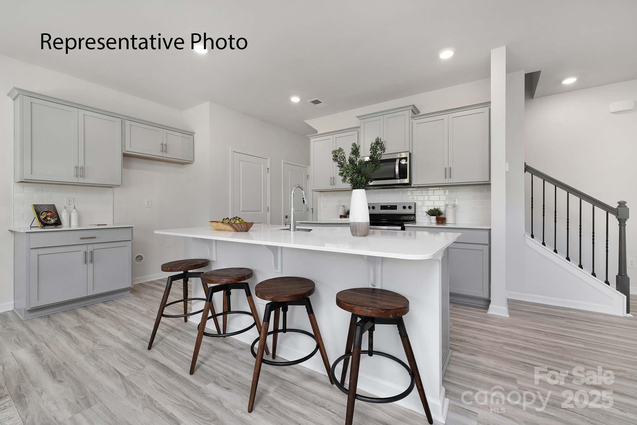 3045 Ora Smith Road Lincolnton, NC 28092 - Photo 14 of 28 a kitchen with stainless steel appliances a white table chairs and a refrigerator