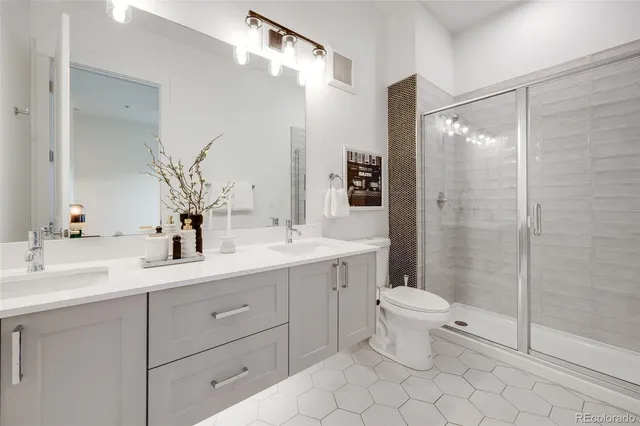 a bathroom with a double vanity sink mirror and toilet