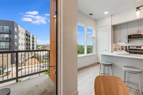 a view of a kitchen from a dining room with windows