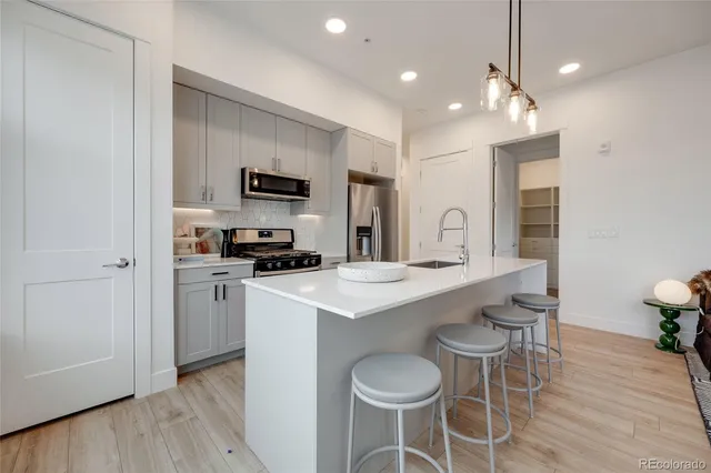 a kitchen with a sink and chairs