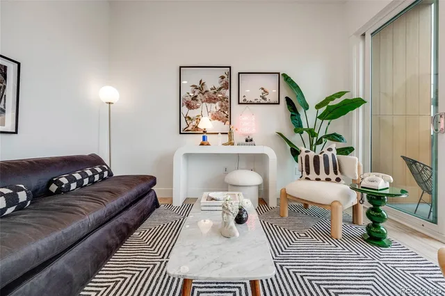 a living room with furniture and a potted plant on table