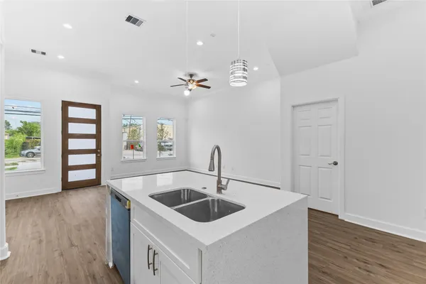 a kitchen with a sink cabinets and wooden floor