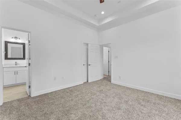 an empty room with wooden floor ceiling fan and window