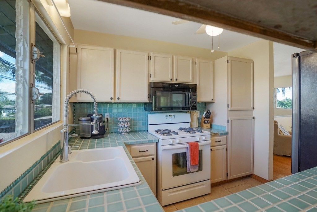 8520 Elepaio Road Kekaha, HI 96752 - Photo 8 of 30 a kitchen with stainless steel appliances a stove a sink and a refrigerator