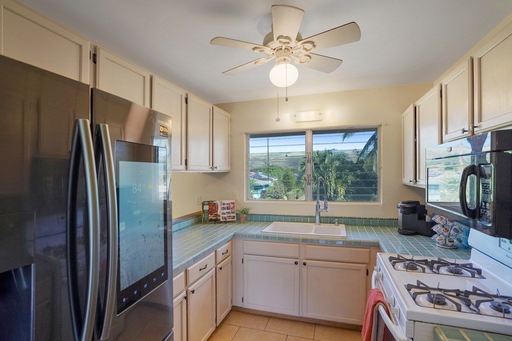 8520 Elepaio Road Kekaha, HI 96752 - Photo 9 of 30 a kitchen with stainless steel appliances granite countertop a sink stove and refrigerator