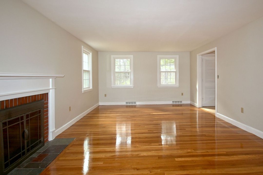 23 Campbell Road Wayland, MA 01778 - Photo 3 of 24 a view of empty room with wooden floor and fireplace