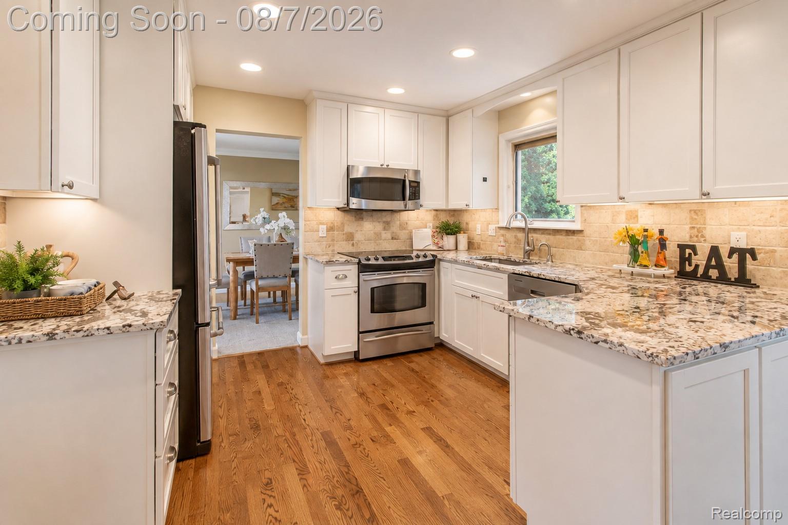 3149 Tamarron Drive Rochester, MI 48309 - Photo 13 of 48 Kitchen featuring white shaker cabinetry, granite countertops, hardwood flooring, stainless steel appliances, and recessed lighting