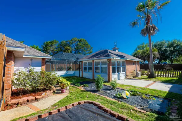a view of a house with a big yard plants and large trees