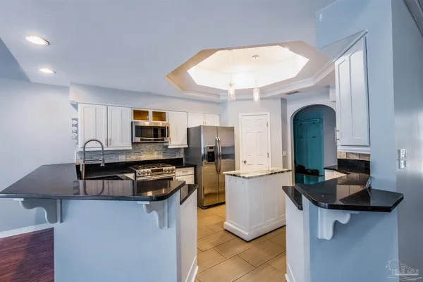 a kitchen with stainless steel appliances granite countertop a sink and a stove